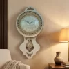 ساعة حائط خشبية فاخرة بتصميم كلاسيكي. مصنوعة من الخشب، تتميز بإطار ذهبي مزخرف وأرقام عربية. مثالية لغرفة المعيشة أو المكتب.