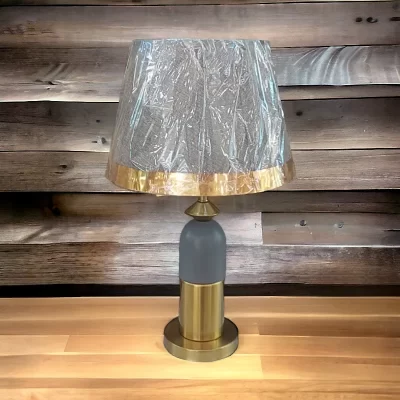 أباجورة نوم بقاعدة معدنية حديثة على شكل إسطوانى موديل 028506 أباجورة نوم معدنية حديثة موديل 028506 رمادى على سطح خشبى 1.webp