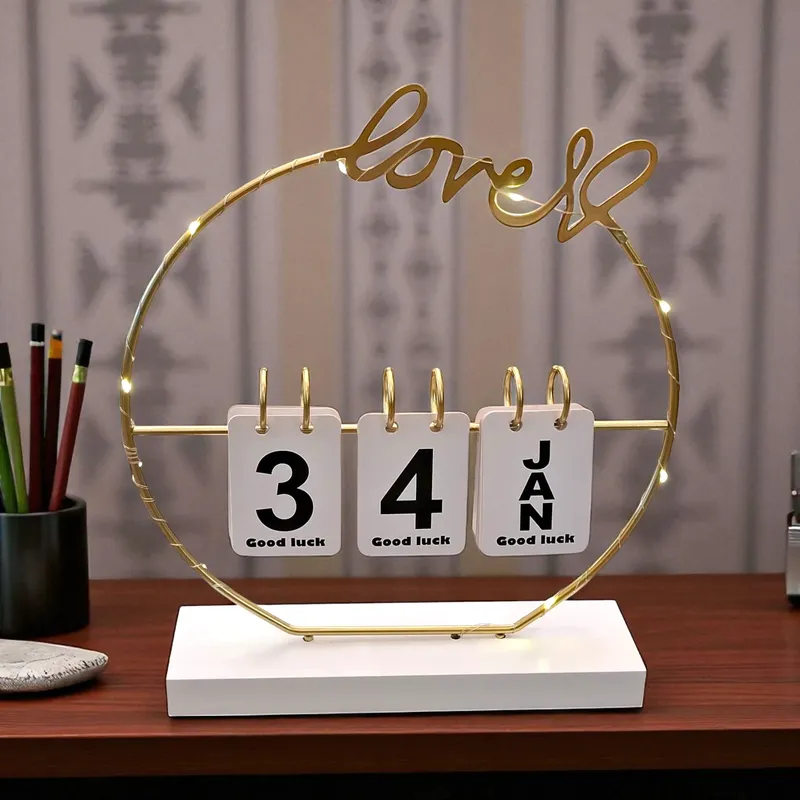 تقويم مكتبي ذهبي وأبيض مضيء بتصميم "Love" مع أرقام وشهور قابلة للتغيير، يضيء المساحات الداخلية ويضيف لمسة جمالية.