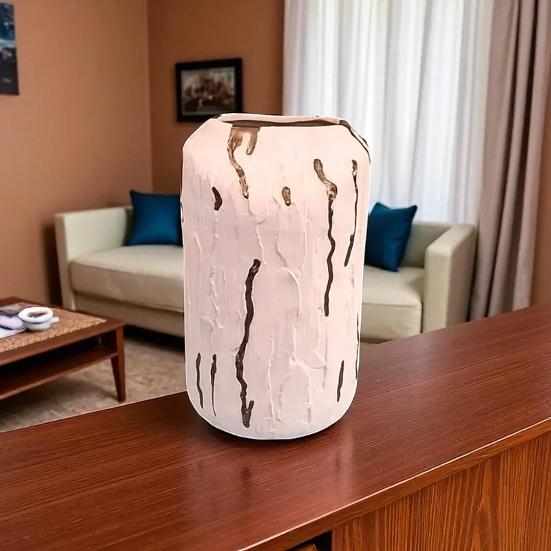 فازة بورسلين عصرية باللون الأبيض الكريمي مع تفاصيل ذهبية بارزة، بتصميم فريد يناسب الديكورات الحديثة والكلاسيكية.