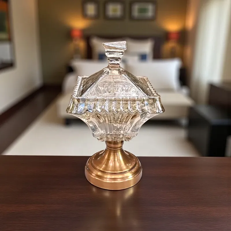 بونبونيرة كريستال كلاسيكية فاخرة بقاعدة ذهبية – تحفة ديكور أنيقة، موديل 022668 بونبونيرة زجاجية كريستالية شفافة مع غطاء، موضوعة على قاعدة معدنية ذهبية لامعة.