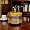 صورة بونبونيرة معدنية ذهبية بغطاء، تستخدم كقطعة ديكور منزلية أنيقة لتقديم الحلويات.