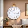 ساعة حائط بيضاء بإطار نقي وغزال ذهبي، تصميم عصري فاخر لديكور المنزل.