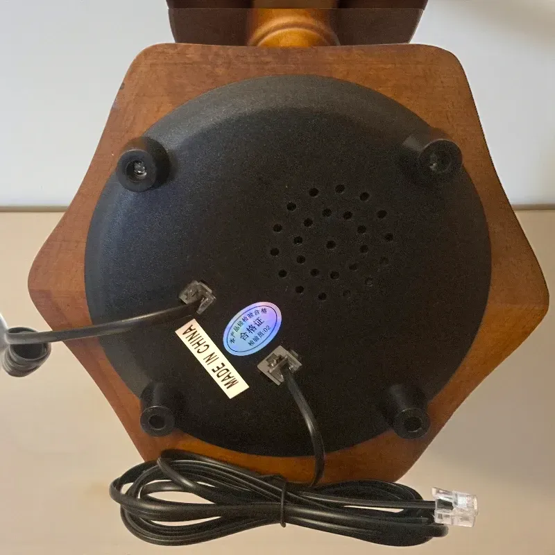 إخوان سرور الإضاءة الحديثة والديكور الجزء السفلي من هاتف أرضي عتيق بفتحات الكابل وعلامة "صنع في الصين"