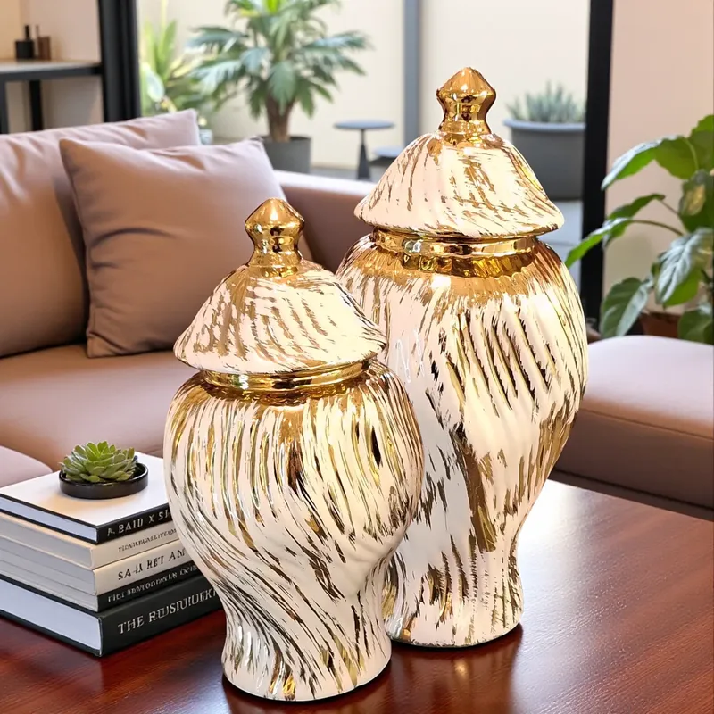 ديكور داخلي يضم طقم فازات زنجبيل سيراميك فاخر بغطاء باللونين الذهبي والأبيض موضوع على طاولة خشبية بجوار أريكة.