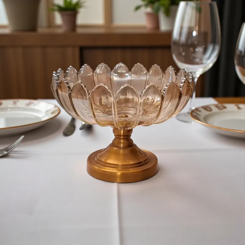 طبق كريستال لتقديم الفواكه بتصميم زهرة اللوتس وقاعدة معدنية برونزية، موضوع على طاولة طعام بيضاء.
