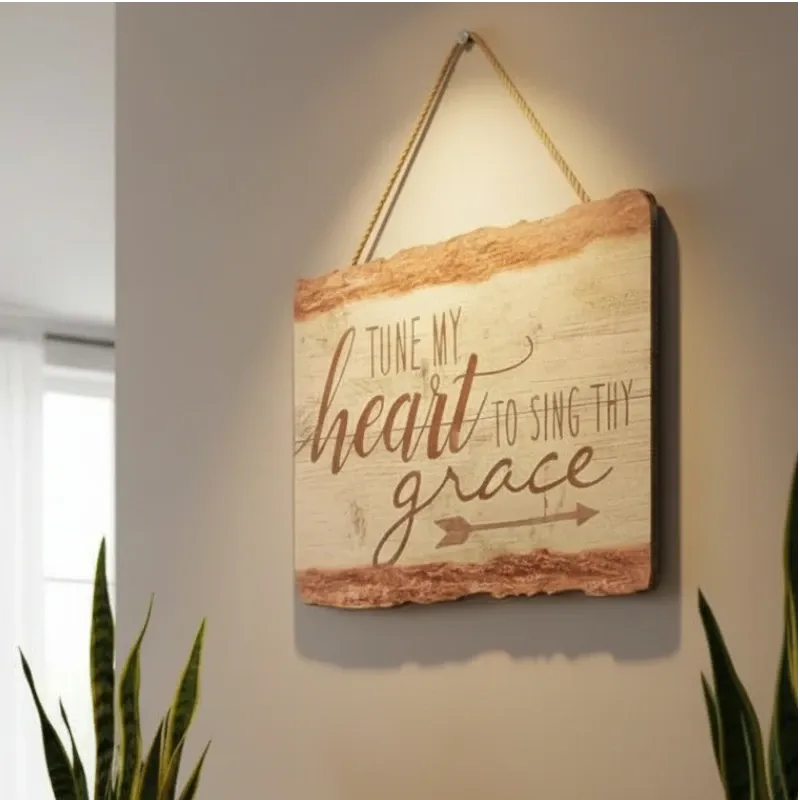 صورة جانبية للوحة جدارية خشبية معلقة بعبارة "TUNE MY HEART TO SING THY GRACE" بخط أنيق وتصميم ريفي.