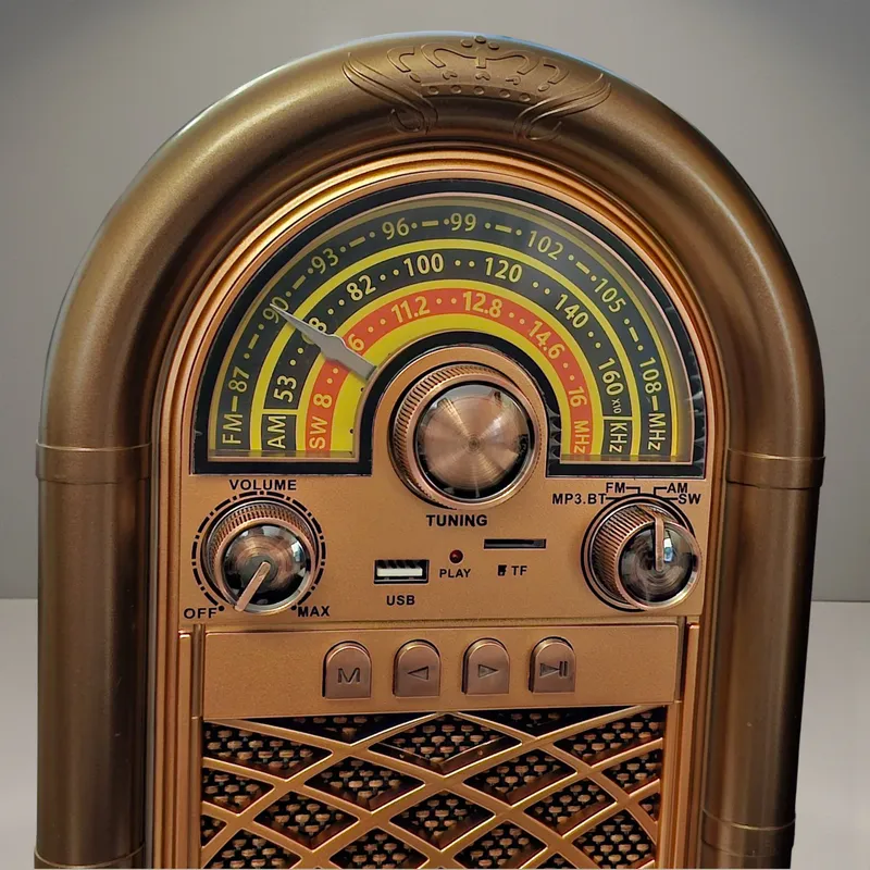 لقطة مقربة لمقياس الترددات (FM/AM/SW) وأزرار التحكم الأمامية في راديو الريترو الذهبي، بما في ذلك مفتاح VOLUME ومقبض TUNING ومؤشر MP3/BT/FM/AM/SW.