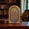 راديو ريترو (Jukebox) ذهبي فاخر على مكتب خشبي في مكتبة، يُظهر مفاتيح التحكم والأقراص ومقياس الترددات.