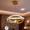 نجفة علاقي مودرن ليد باللون الذهبي بتصميم حلقتين وكورة كريستال مع إضاءة خافتة بريموت.