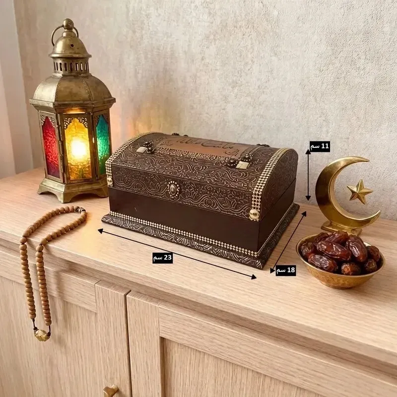 صندوق حفظ المصحف الشريف مع المصحف، خشبي فاخر بزخارف إسلامية، موديل 019555 مخطط قياسات علبة حفظ المصحف الخشبية يوضح الطول 23 سم، العرض 18 سم، والارتفاع 11 سم على طاولة خشبية.