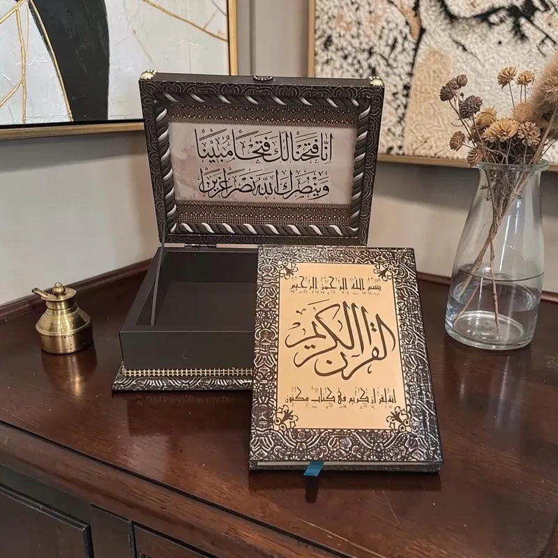 صندوق حفظ المصحف الشريف مع المصحف، خشبي فاخر بزخارف إسلامية، موديل 019555 صندوق قرآن كريم مفتوح يظهر آيات الفتح بالداخل مع نسخة المصحف الشريف ذات الغلاف المذهب الفاخر.