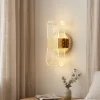 أبليك حائط مودرن بتصميم الساعة الرملية مضاء بأكريليك الفقاعات يعطي إضاءة دافئة بجوار السرير.