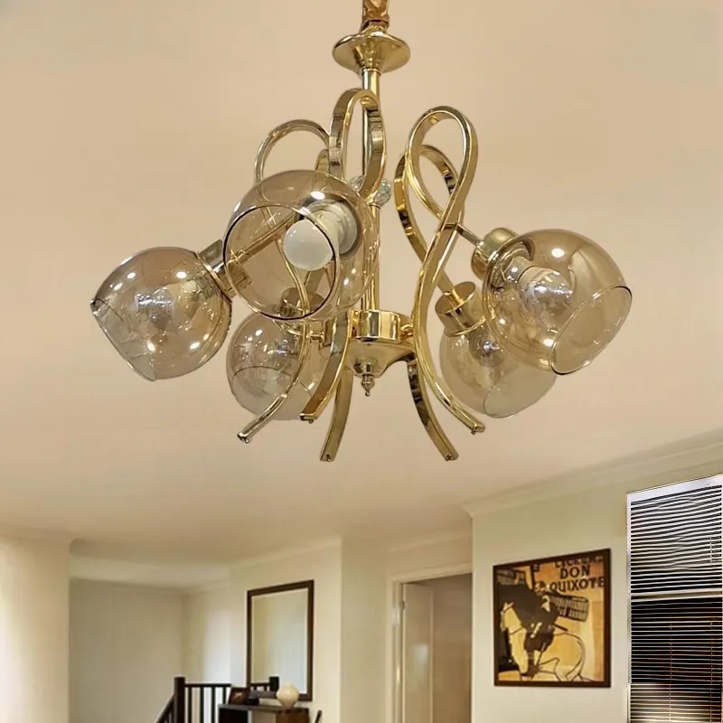 نجفة ذهبية أنيقة بتصميم كلاسيكي ب 5 كلوبات عسلية تعكس الأناقة والرقي. مثالية لإضفاء لمسة دافئة وجذابة على أي غرفة معيشة أو غرفة نوم. وتظهر مطفأة داخل غرفة