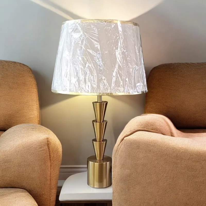 أباجورة نوم عصرية بتصميم أنيق تتميز بغطاء من القماش الكتان باللون الأبيض الكريمى وقاعدة معدنية بلون نحاسى لامعة. توفر هذه الأباجورة إضاءة دافئة ومريحة لغرفة نومك أو أي مساحة أخرى في منزلك.