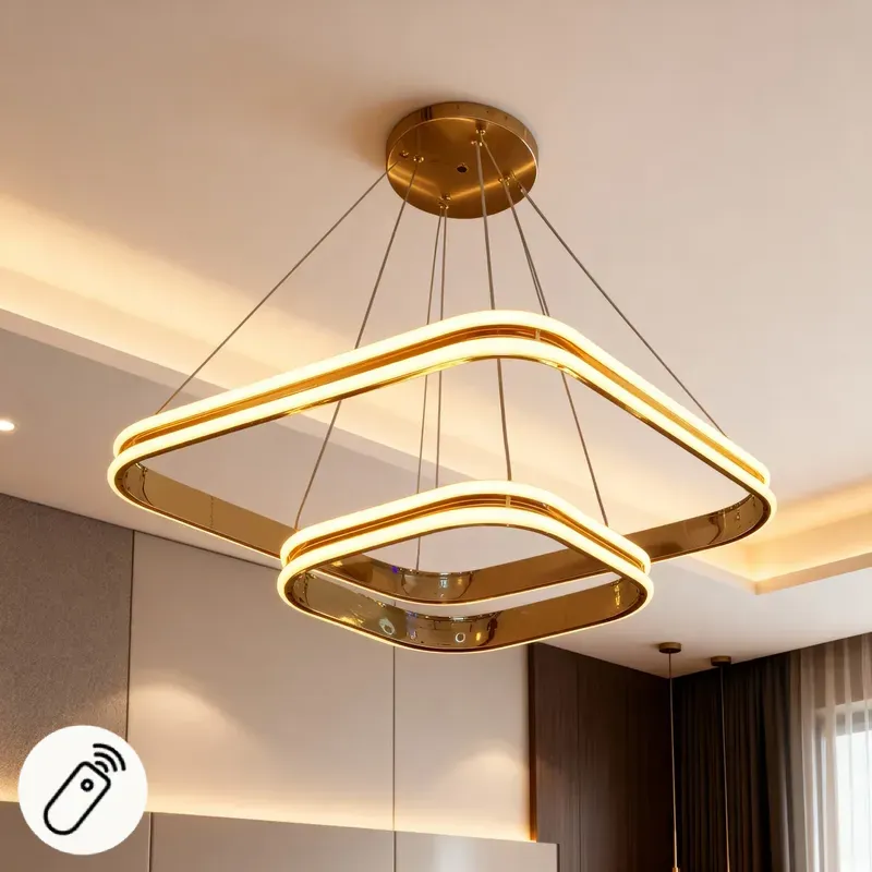 نجفة LED مودرن بتصميم مربع مزدوج باللون الذهبي اللامع، معلقة بأسلاك رفيعة في سقف غرفة معيشة عصرية، وتتضمن رمز التحكم عن بُعد.