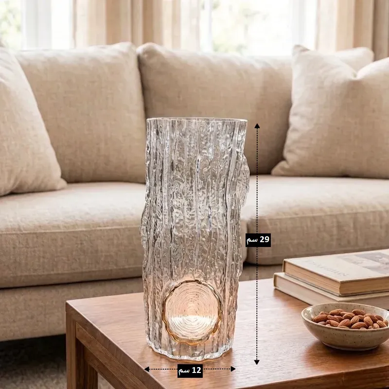 فازة زجاجية شفافة بتصميم جذع شجرة فارغة توضح أبعاد الارتفاع 29 سم والعرض 12 سم.