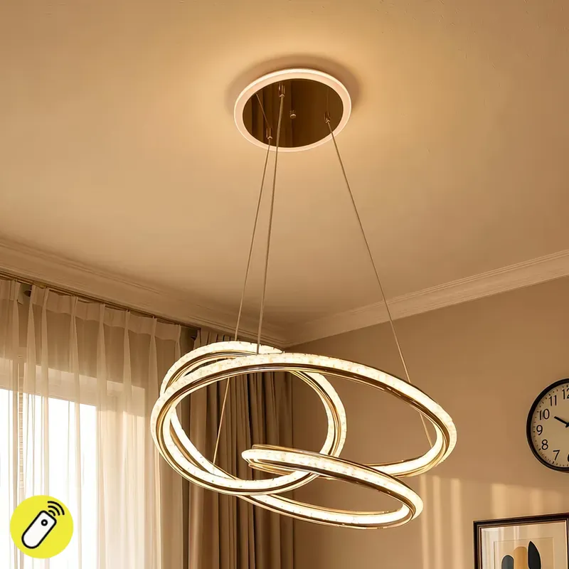 نجفة ليد مودرن ذهبية ثلاثية الحلقات متداخلة و مضيئة بإضاءة دافئة.